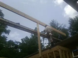 Carpenter setting a ridge beam over a new addition frame — Ice Dam Removal by Roofing Brothers in Vernalis