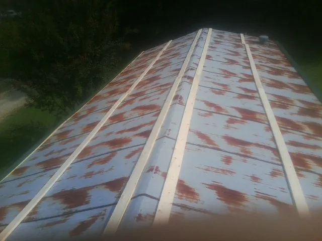Rusted metal roof panels with new wood purlins before replacement — Storm Damage Roof Repair in Vernalis by Roofing Brothers