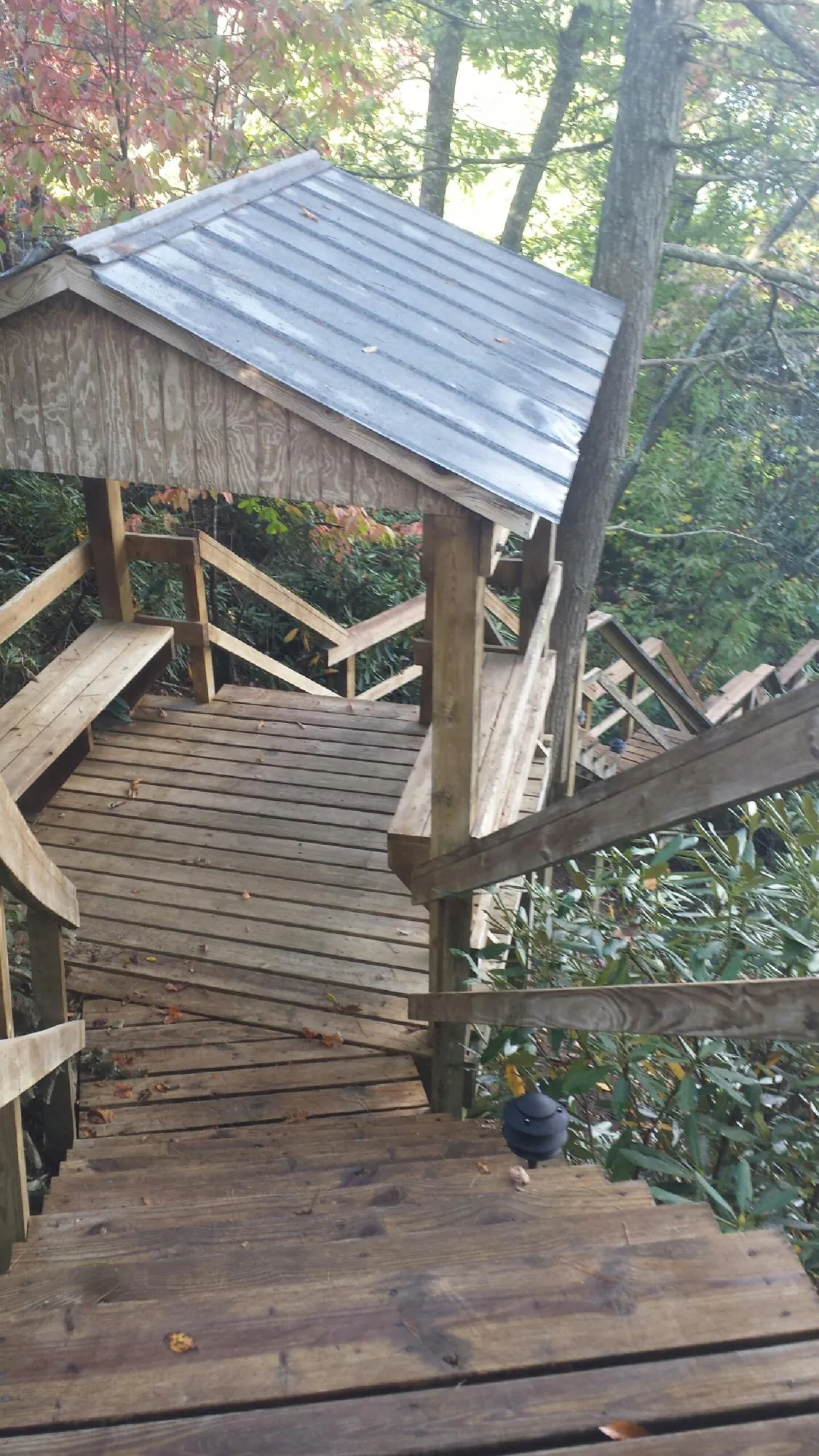 Metal roofed shelter over wooden steps on a wooded walkway — Skylight Repair & Installation work by our crew in Vernalis